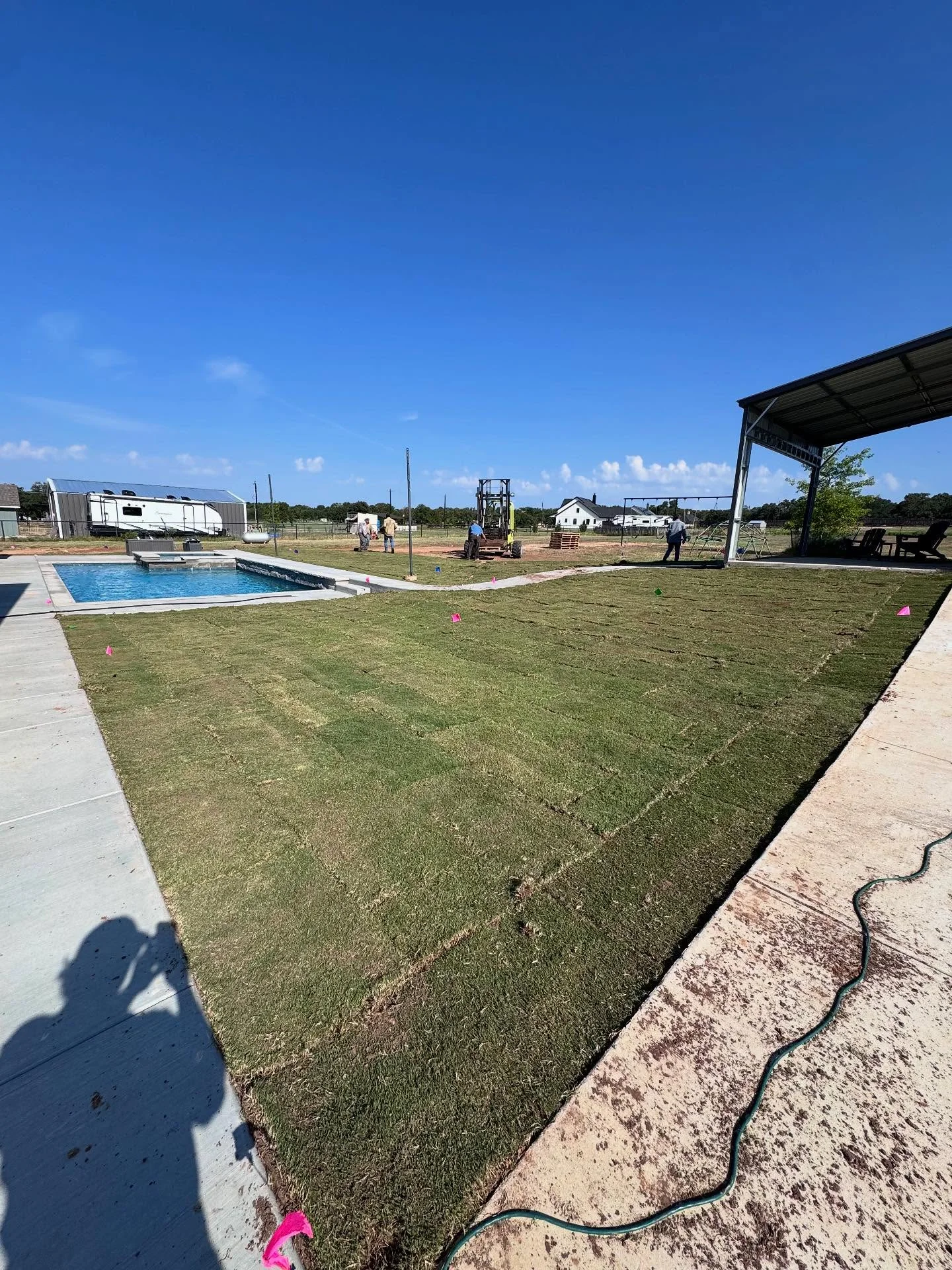 Irrigation system design and layout markers on a newly sodded residential property with pool and patio in Weatherford, TX